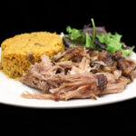 Plato de Pernil — Puerto Rican slow-roasted pulled pork with arroz con gandules and mixed greens salad at Phoenix Coqui, Phoenix AZ.